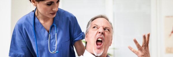Patient on a wheelchair getting angry with nurse