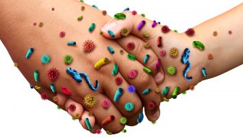 Infectious diseases spread hygiene concept as people holding hands with germ virus and bacteria spreading with illness in public as a health care risk concept to not wash your hands as dirty infected fingers and palm with contagious pathogens.