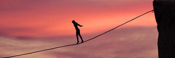 Silhouette of young businesswoman called on all her courage to walk on the rope at mountain. Business challenge concept
** Note: Visible grain at 100%, best at smaller sizes