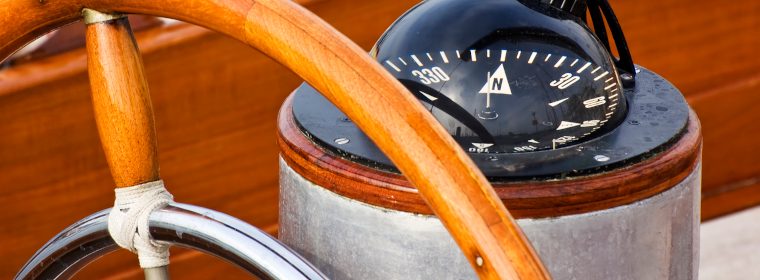 Rudder and compass on a wooden boat