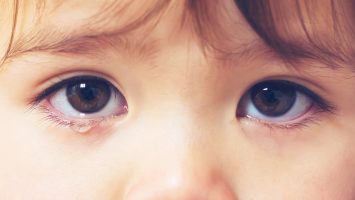 Crying toddler girl being consoled by her mother