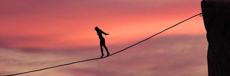 Silhouette of young businesswoman called on all her courage to walk on the rope at mountain. Business challenge concept
** Note: Visible grain at 100%, best at smaller sizes